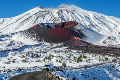 Volcan Etna enneigé avec cratère de lave rouge