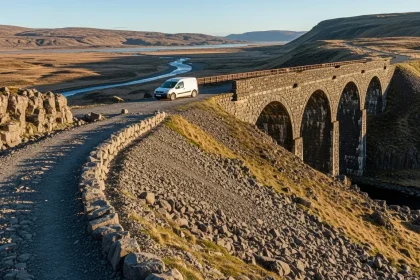 Van blanc sur route abandonnée avec viaduc ancien
