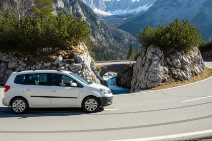 Van blanc naviguant un virage serré sur le col de Vršič