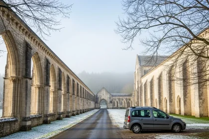 Abbaye cistercienne émergeant du brouillard avec van gris