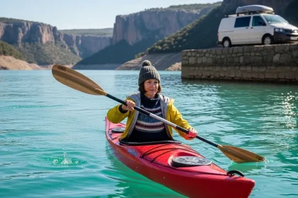 Femme pagayant en kayak sur un lac turquoise