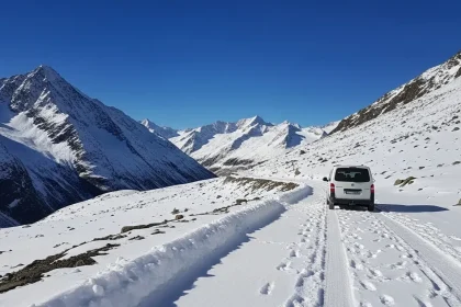 Van blanc sur route enneigée dans les Alpes